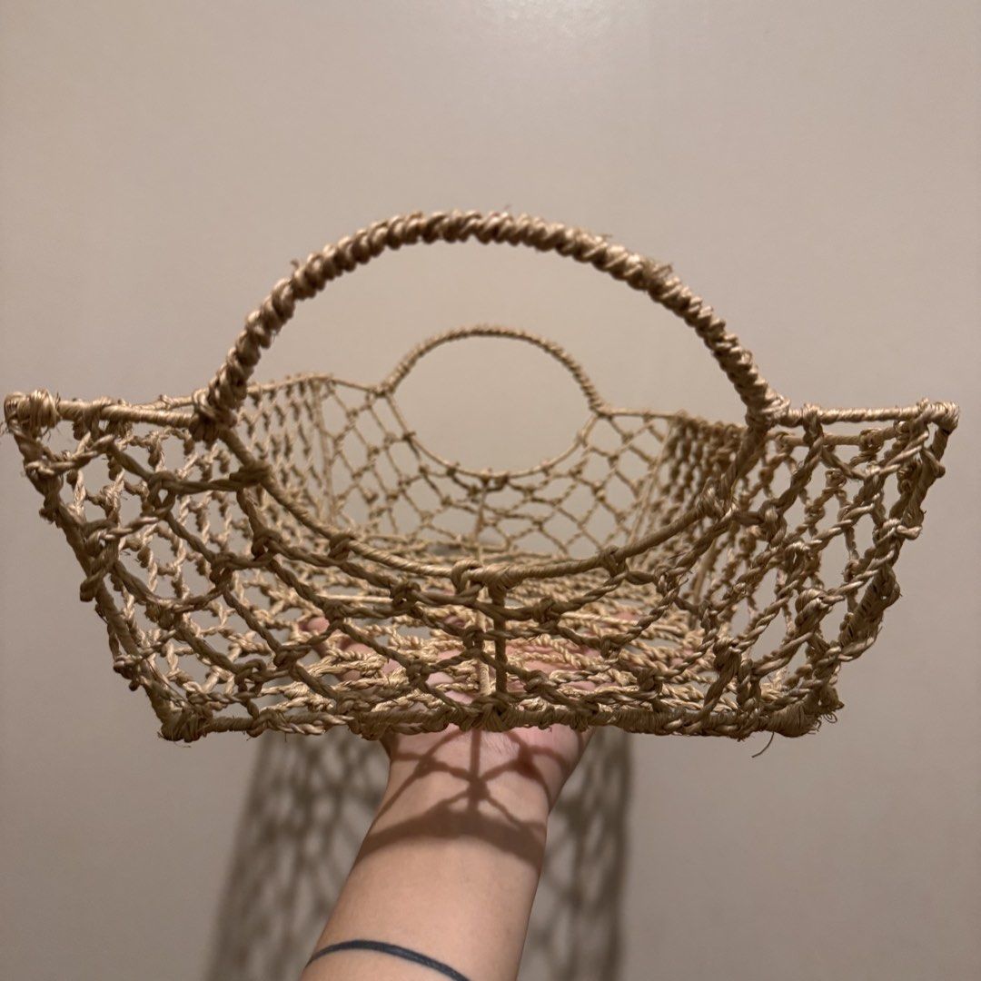 Woven jute storage basket with circular handles (Category: Storage Boxes & Baskets) located in Quezon City. Submitted by ianne.declutter (Listing ID 1470049511, Image 2). Description: - Material: 100% natural jute rope in a neutral beige tone - Design: Rectangular shape with an open mesh weave - Features: Sturdy circular handles on both ends for easy carrying - Versatile: Ideal for organizing living room shelves, bathroom toiletries, or kitchen p