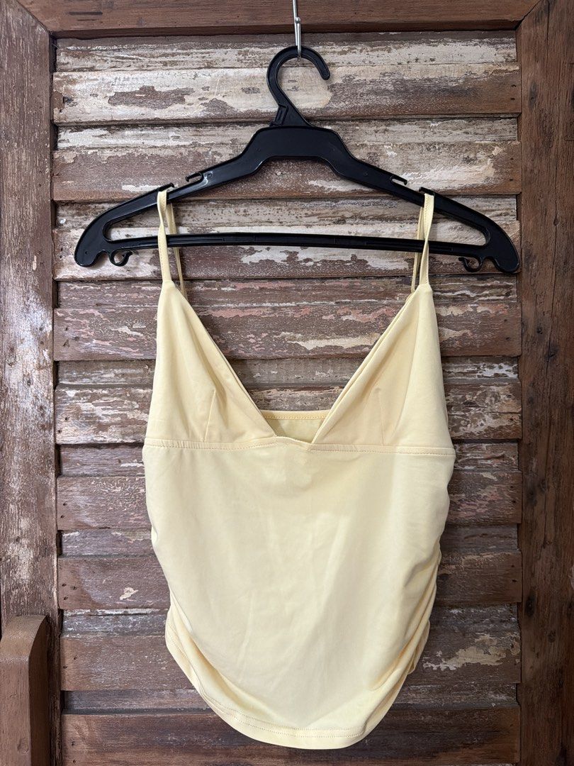 Yellow Cami Top with Ruched Sides V-Neck (Category: Sleeveless) located in Manila. Submitted by cb_____ (Listing ID 1469968735, Image 1). Description: - Color: Pastel yellow - Fit: Slightly cropped at the waist with a curved hem - Neckline: V-neck front with a straight back - Straps: Thin spaghetti straps with metal adjusters - Details: Flattering ruching gathered along both side seams - Material: Lightweight and comfortable - Condition: Clean pi