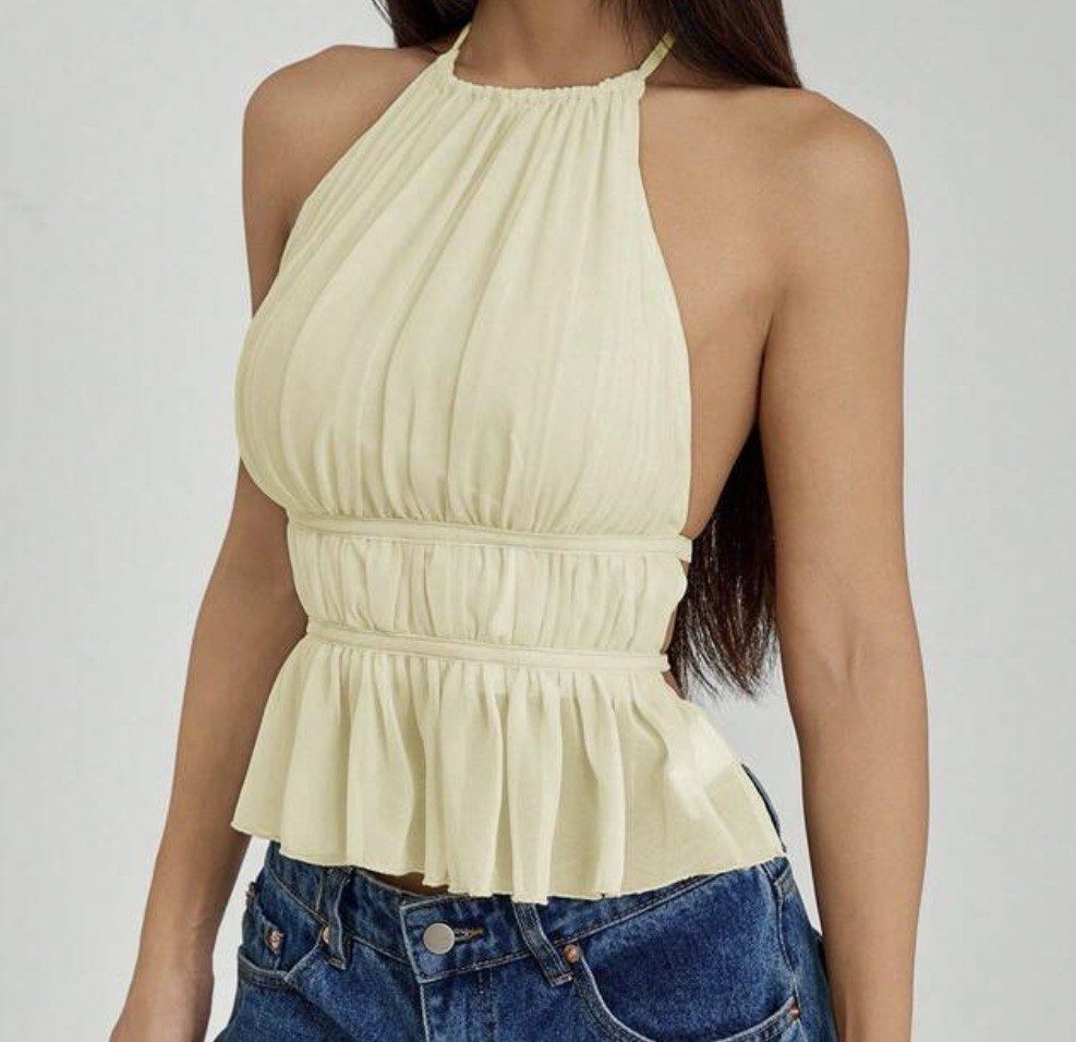 Yellow Halter Neck Ruffle Peplum Top (Category: Sleeveless) located in Caloocan City. Submitted by lexs.finds (Listing ID 1470061959, Image 1). Description: - Color: Light yellow - Style: Halter neck top with open back design - Fit: Cinched waist with a flared peplum hem - Fabric: Lightweight material with pleats through the bodice - Pairing: Looks great styled with denim jeans.