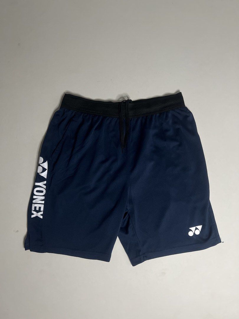Yonex Navy Blue Athletic Shorts with Drawstring (Category: Shorts) located in Tacloban City. Submitted by thrftg (Listing ID 1470086386, Image 1). Description: - Brand: Yonex - Color: Dark Navy Blue - Material: Lightweight, breathable mesh-style fabric - Features: Elastic waistband with adjustable black drawstring - Branding: Vertical white Yonex logo on the left leg and smaller logo on the right hem - Ideal for: Badminton, tennis, and other spor