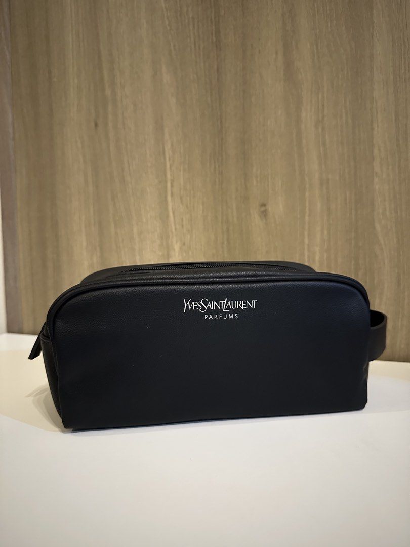 Yves Saint Laurent Parfums Black Toiletry Pouch (Category: Purses & Pouches) located in Manila. Submitted by kevintotin49861 (Listing ID 1470089942, Image 1). Description: - Brand: Yves Saint Laurent Parfums - Color: Classic black with white front branding - Material: Premium faux leather - Closure: Zip closure with YSL embossed matching pull tab - Interior: Lined with printed text and black YSL brand label - Condition: Excellent, clean, and no s