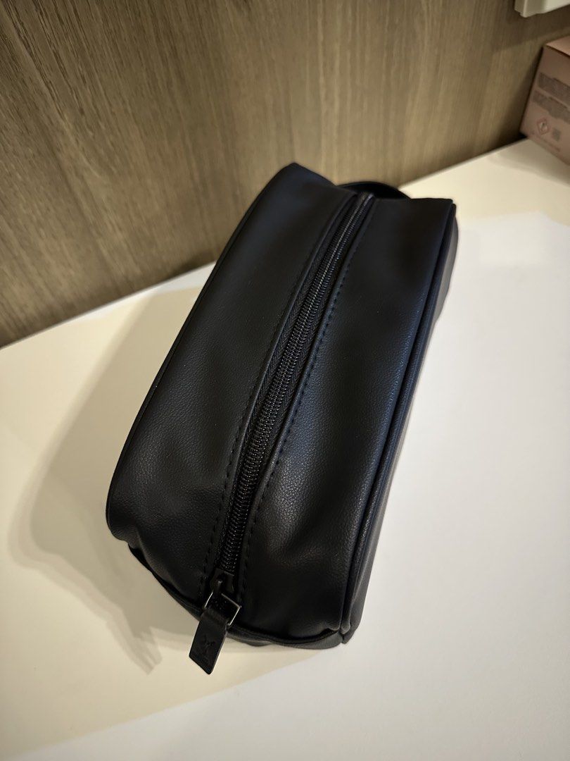 Yves Saint Laurent Parfums Black Toiletry Pouch (Category: Purses & Pouches) located in Manila. Submitted by kevintotin49861 (Listing ID 1470089942, Image 2). Description: - Brand: Yves Saint Laurent Parfums - Color: Classic black with white front branding - Material: Premium faux leather - Closure: Zip closure with YSL embossed matching pull tab - Interior: Lined with printed text and black YSL brand label - Condition: Excellent, clean, and no s
