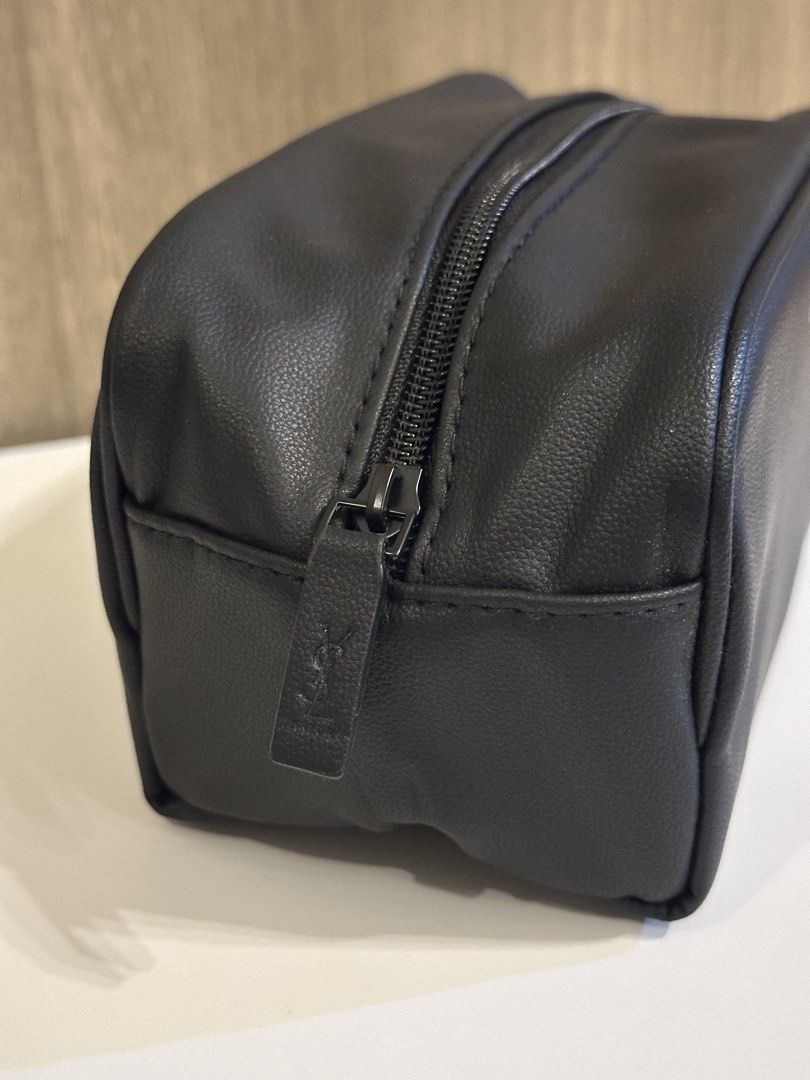 Yves Saint Laurent Parfums Black Toiletry Pouch (Category: Purses & Pouches) located in Manila. Submitted by kevintotin49861 (Listing ID 1470089942, Image 3). Description: - Brand: Yves Saint Laurent Parfums - Color: Classic black with white front branding - Material: Premium faux leather - Closure: Zip closure with YSL embossed matching pull tab - Interior: Lined with printed text and black YSL brand label - Condition: Excellent, clean, and no s