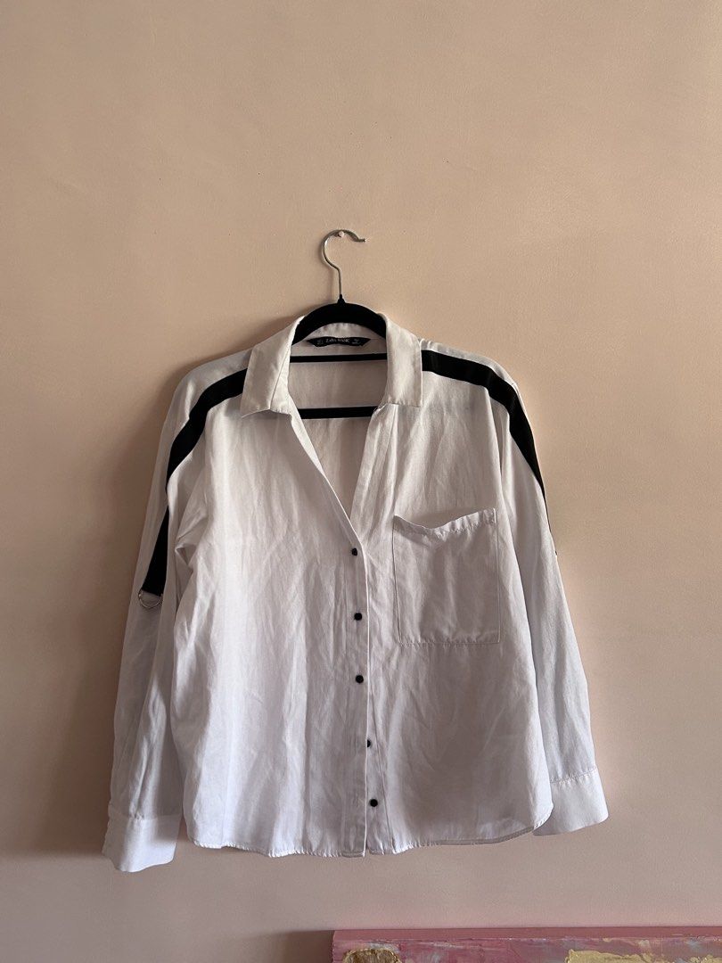 Zara Basic White Button-Down Shirt with Black Stripes Size S (Category: Shirts) located in Cebu City. Submitted by shopmikascloset (Listing ID 1469956263, Image 1). Description: - Brand: Zara Basic - Size: S (Made in Morocco) - Color: White with contrast black stripes on shoulders and sleeves - Details: Metal ring on right sleeve and single left chest pocket - Style: Standard collar, button cuffs, clean and versatile.