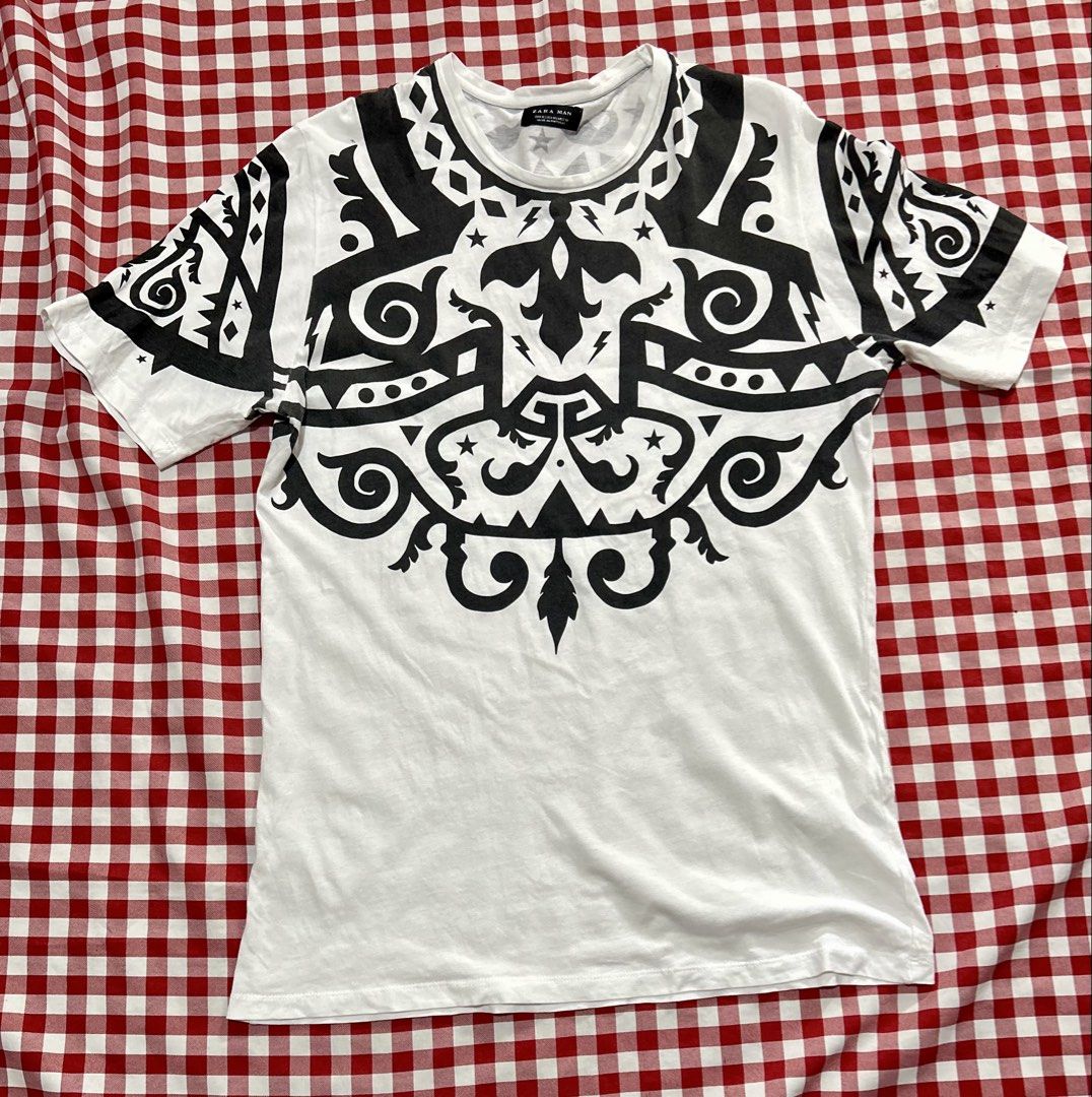 Zara Man Print Graphic T-Shirt (Category: Tshirts & Polo Shirts ) located in Plaridel. Submitted by ilovebubu28 (Listing ID 1469954441, Image 1). Description: - Brand: Zara Man - Style: Short sleeve crew neck tee with bold black tribal graphic print - Print Details: Matching graphic across chest, shoulders, and back - Size: Medium (M) - Material: 100% Cotton - Origin: Made in Portugal - Condition: Excellent, fabric care label intact.