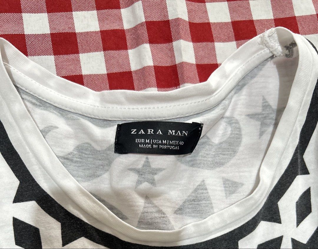 Zara Man Print Graphic T-Shirt (Category: Tshirts & Polo Shirts ) located in Plaridel. Submitted by ilovebubu28 (Listing ID 1469954441, Image 3). Description: - Brand: Zara Man - Style: Short sleeve crew neck tee with bold black tribal graphic print - Print Details: Matching graphic across chest, shoulders, and back - Size: Medium (M) - Material: 100% Cotton - Origin: Made in Portugal - Condition: Excellent, fabric care label intact.