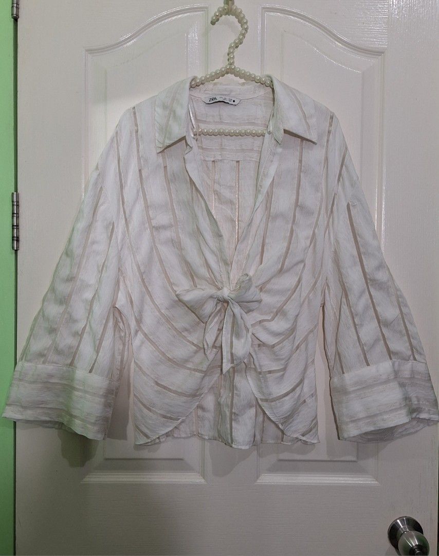 Zara pleated draped blouse large mango topshop T3 (Category: Blouses) located in San Pablo. Submitted by allyourbrandedneeds (Listing ID 1469969529, Image 3). Description: - Brand: Zara - Color: White with vertical sheer stripes - Details: Front knot tie, collar neckline, long sleeves with wide cuffs - Size: EUR L / USA L / MEX 30 - Made in: Turkey - Condition: Clean, excellent, ready to wear - Style: Great wardrobe staple for casual days or laye