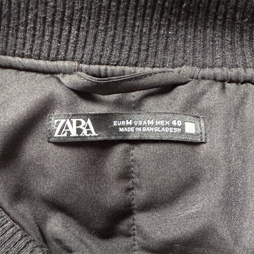 Zara Retro Speed Bomber Jacket Size M (Category: Coats, Jackets and Outerwear) located in Pura. Submitted by rarefindsph1205 (Listing ID 1470017329, Image 3). Description: - Brand: Zara - Style: Racing-style colourblock bomber jacket - Colourway: Black, orange, grey, and white - Details: 'RETRO SPEED' and 'BLANK CANVAS' patches on front and back - Closure: Snap button front - Trim: Ribbed collar, cuffs, and hem - Size: EUR M, USA M, MEX 40 - Orig