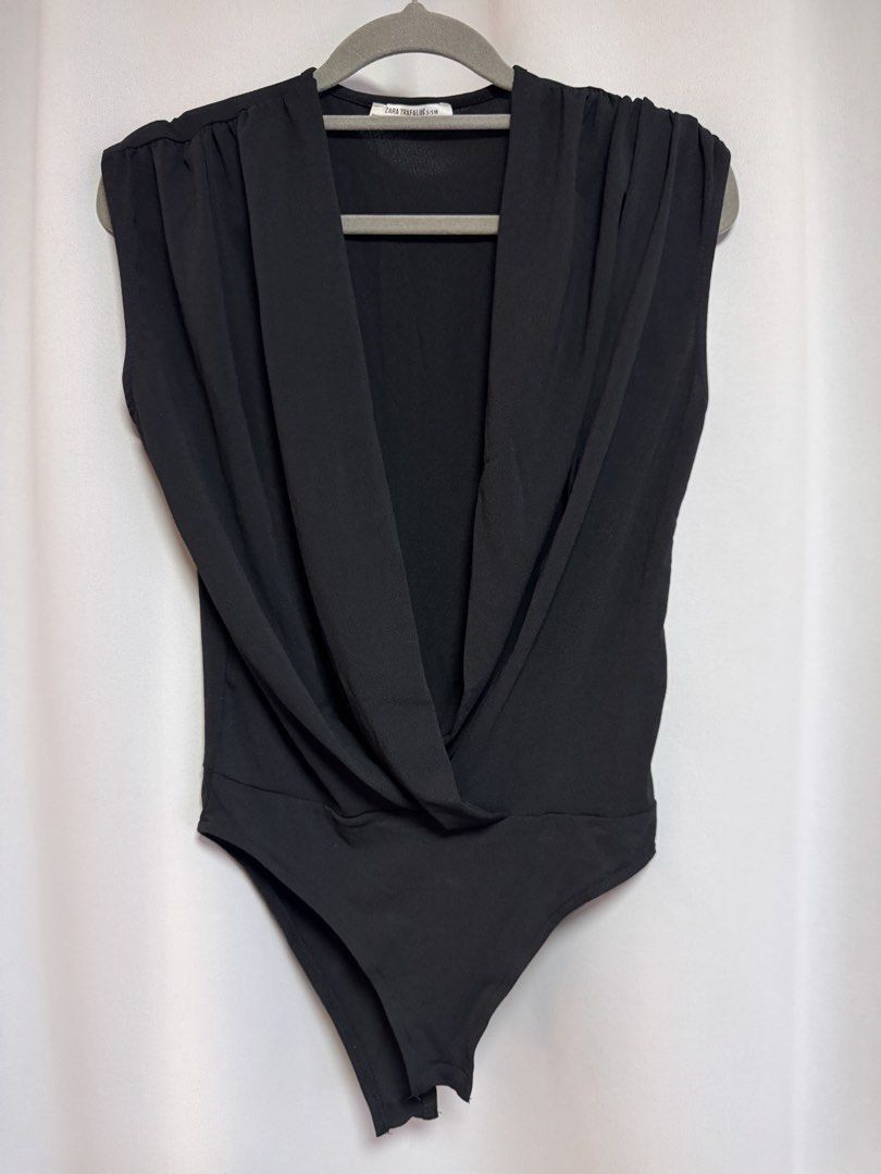 Zara Trafaluc Black Draped Bodysuit Size S (Category: Sleeveless) located in Calamba. Submitted by cheriiv (Listing ID 1469949756, Image 1). Description: With tiny pinholes in front since I put safety pin - Brand: Zara Trafaluc - Style: Sleeveless bodysuit with deep draped V-neck and gathered shoulders - Size: S - Material: Soft, stretchy, and comfortable fabric.
