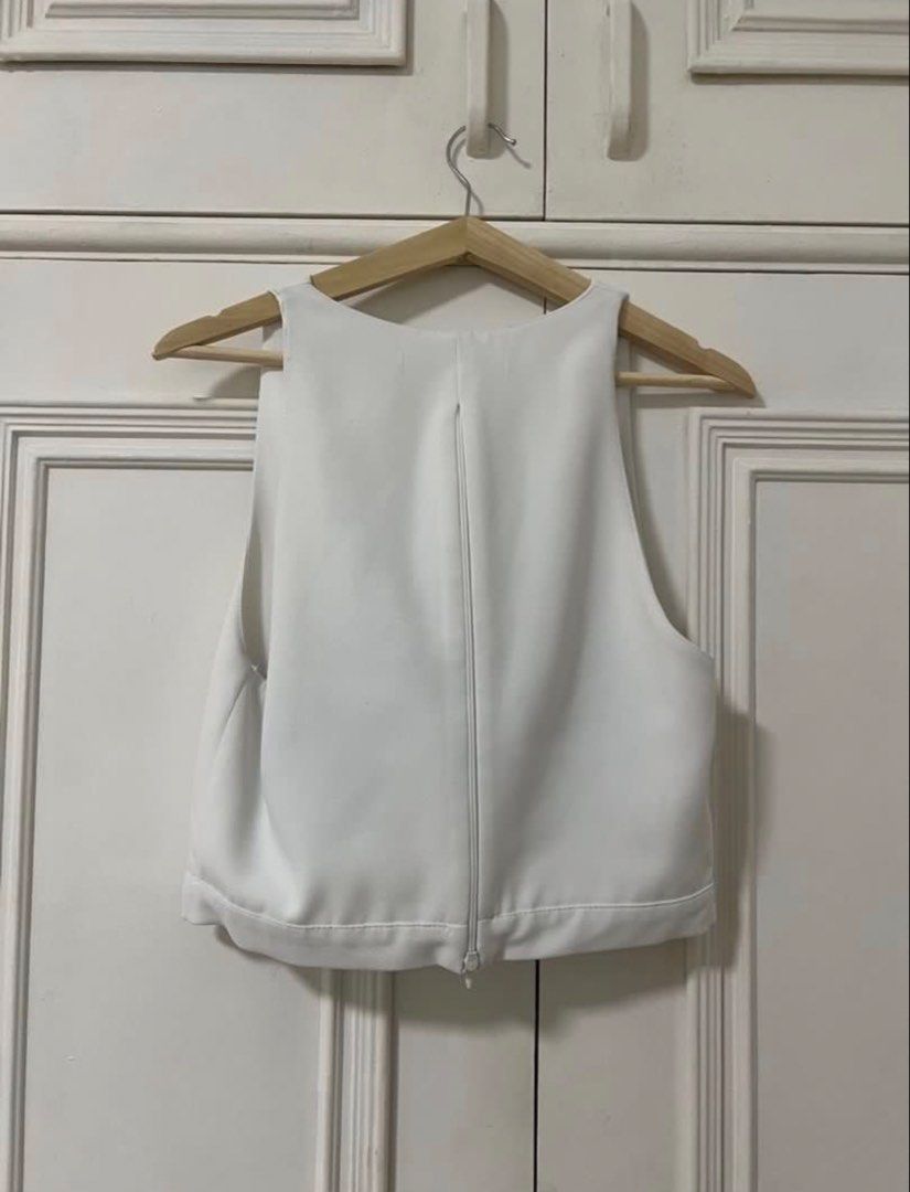 ZARA White cowl neck crop top (Category: Sleeveless) located in Dasmarinas. Submitted by aoe.ae (Listing ID 1470141270, Image 2). Description: - Color: White - Style: Sleeveless crop top with draped cowl neckline - Fit: Structured fabric that holds its shape well - Closure: Full back zipper down the middle - Versatility: Clean minimalist design that pairs easily with high-waisted skirts or trousers.
