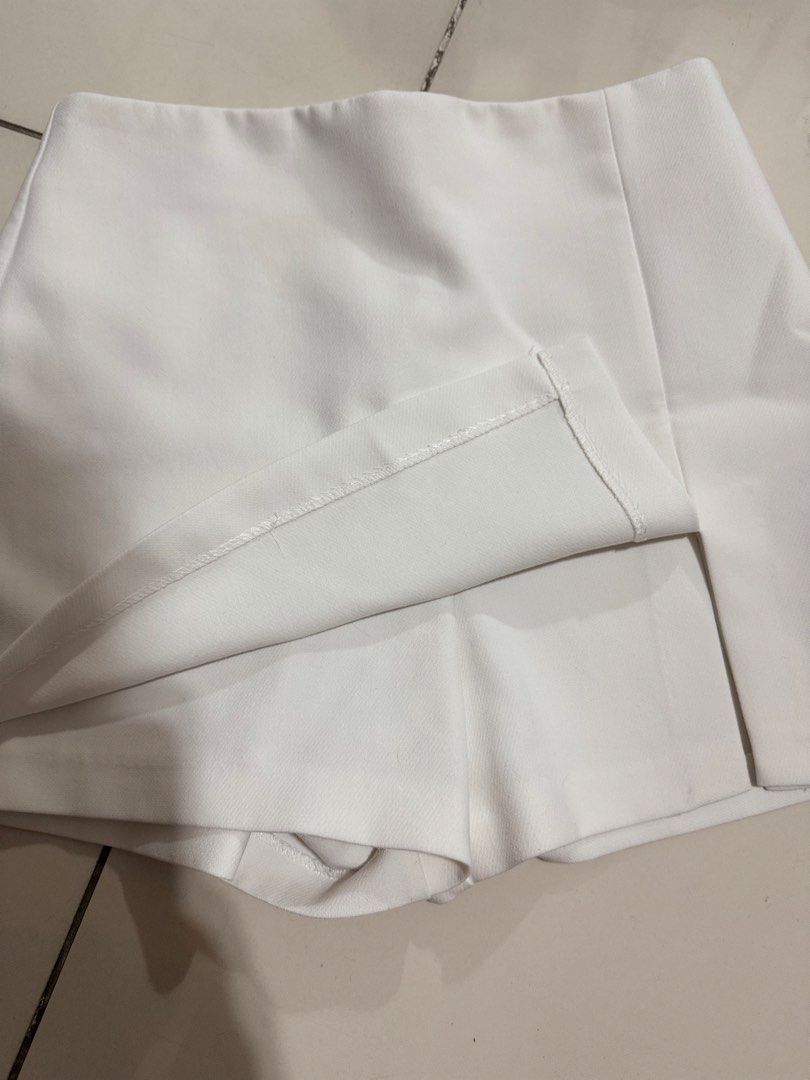 Zara White Mini Skort | Size S (Category: Shorts) located in Manila. Submitted by buymiclothes.47 (Listing ID 1470118683, Image 2). Description: Zara White Wrap-Front Mini Skort | Size S White structured mini skort from Zara 🤍 * Size S (MEX 26) * Asymmetric wrap-style front * Small front slit detail * Built-in shorts underneath * Clean, minimalist design * Easy to dress up or down Condition: Preloved. Please refer to actual photos for condition.