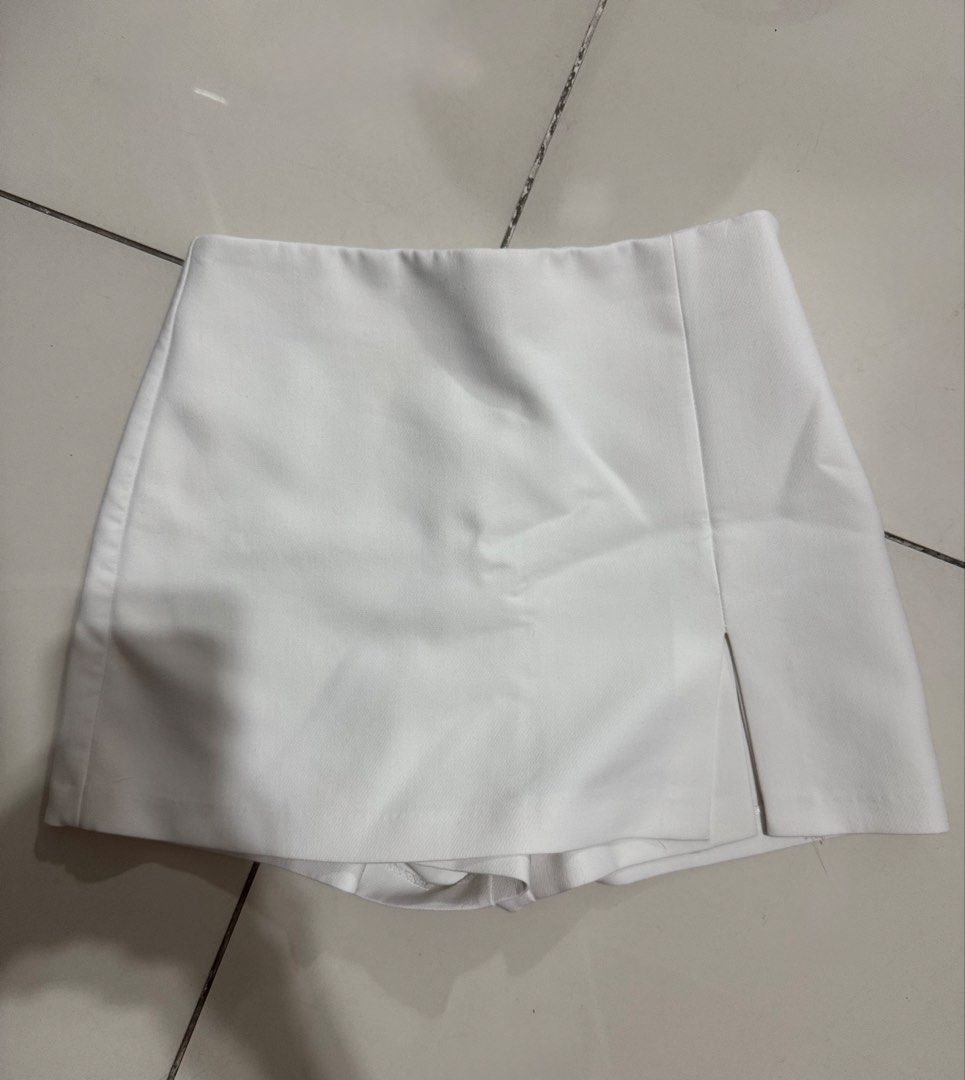 Zara White Mini Skort | Size S (Category: Shorts) located in Manila. Submitted by buymiclothes.47 (Listing ID 1470118683, Image 1). Description: Zara White Wrap-Front Mini Skort | Size S White structured mini skort from Zara 🤍 * Size S (MEX 26) * Asymmetric wrap-style front * Small front slit detail * Built-in shorts underneath * Clean, minimalist design * Easy to dress up or down Condition: Preloved. Please refer to actual photos for condition.