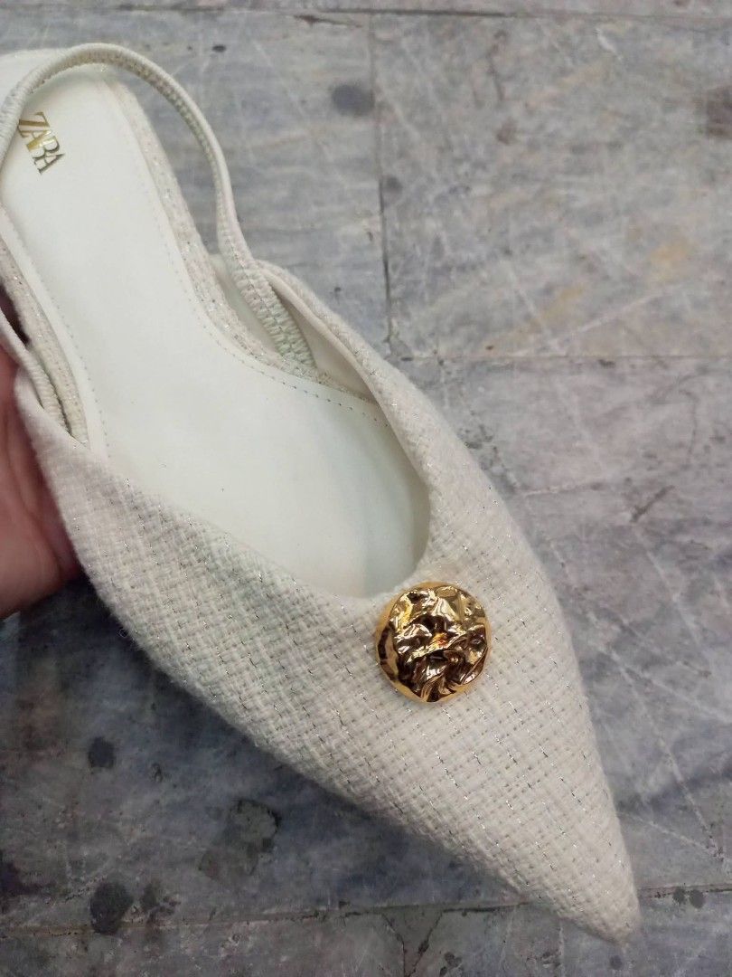 Zara White Slingback Kitten Heels Size 36 (Category: Heels) located in Bay. Submitted by silverhorse-59c851 (Listing ID 1470087234, Image 3). Description: - Brand: Zara - Style: Slingback low kitten heels with slip-on design - Color & Texture: White textured fabric - Details: Pointed toe with elegant gold button accent - Size: 36 - Condition: Clean with minimal wear on the soles.