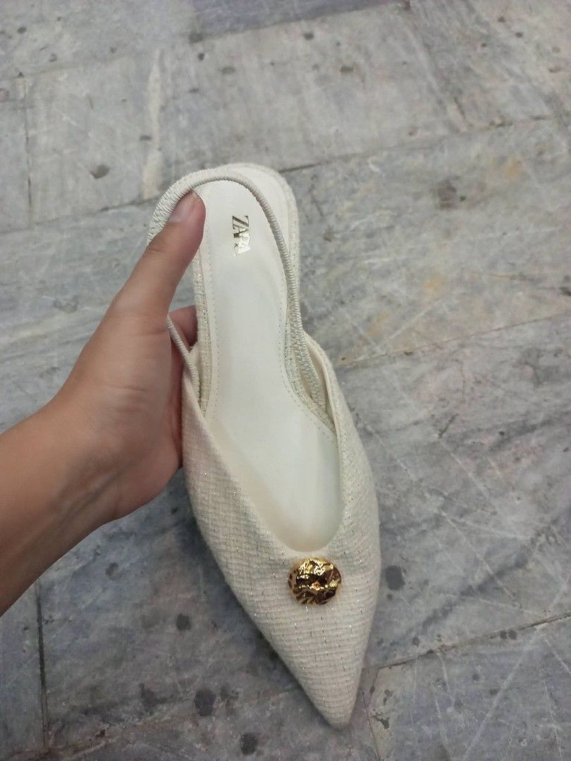Zara White Slingback Kitten Heels Size 36 (Category: Heels) located in Bay. Submitted by silverhorse-59c851 (Listing ID 1470087234, Image 1). Description: - Brand: Zara - Style: Slingback low kitten heels with slip-on design - Color & Texture: White textured fabric - Details: Pointed toe with elegant gold button accent - Size: 36 - Condition: Clean with minimal wear on the soles.
