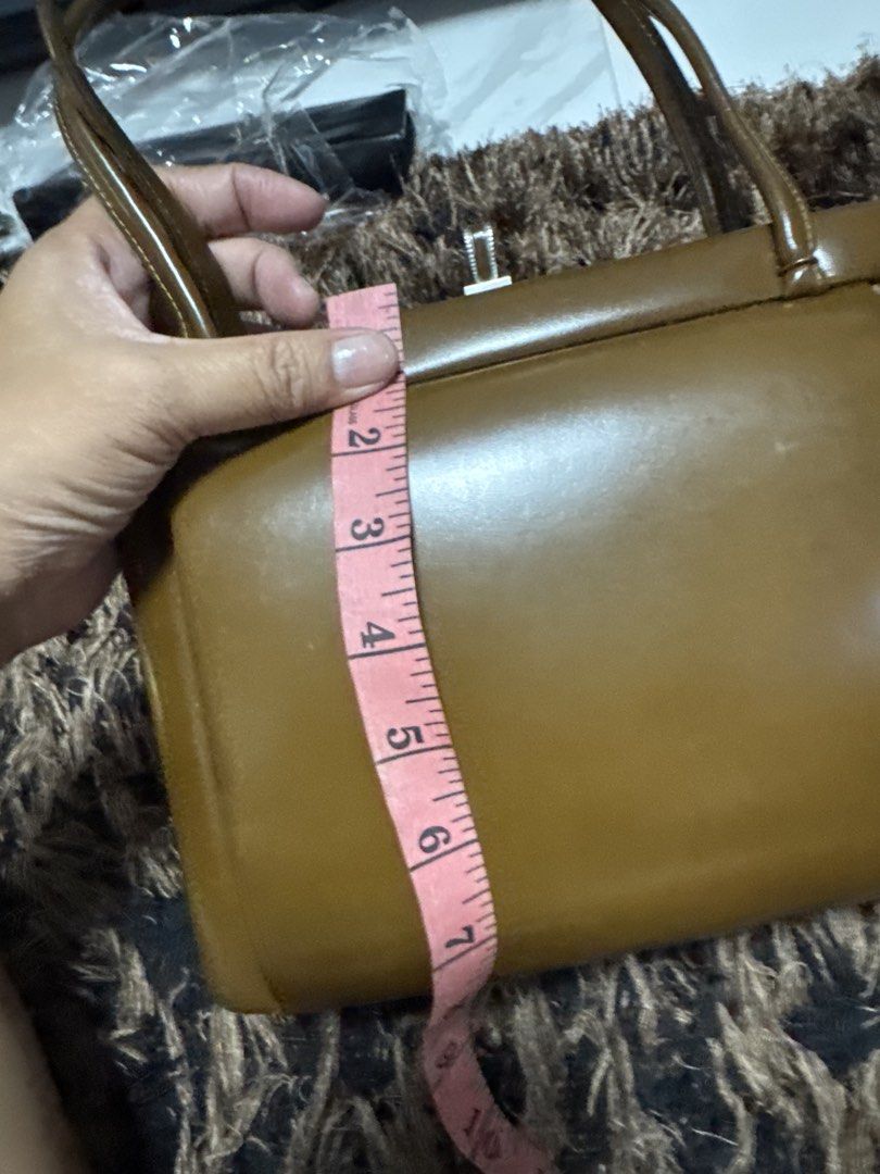2027 WST Vintage Brown Structured Handbag Top Handle Bag (Category: Shoulder Bags) located in Silang. Submitted by sari2bilina (Listing ID 1470178080, Image 2). Description: - Color: Brown - Material: Smooth faux leather - Closure: Top clasp - Handles: Double top handles - Dimensions: Approx. 7" tall x 11" long with a 2" base width - Condition: Minor surface scuffs on the body, clean stitching along edges and handles.