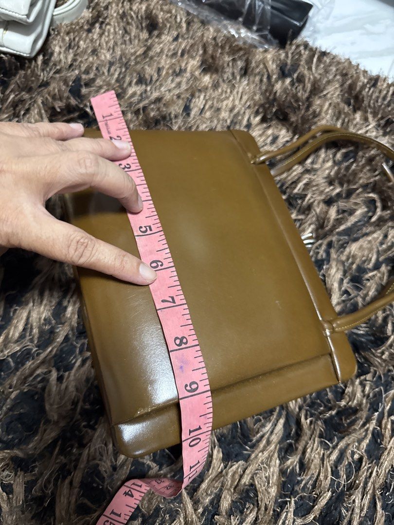 2027 WST Vintage Brown Structured Handbag Top Handle Bag (Category: Shoulder Bags) located in Silang. Submitted by sari2bilina (Listing ID 1470178080, Image 3). Description: - Color: Brown - Material: Smooth faux leather - Closure: Top clasp - Handles: Double top handles - Dimensions: Approx. 7" tall x 11" long with a 2" base width - Condition: Minor surface scuffs on the body, clean stitching along edges and handles.