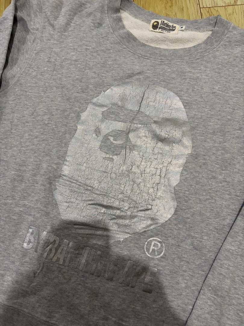 A Bathing Ape BAPE Ape Head Grey Sweatshirt Size M (Category: Coats, Jackets and Outerwear) located in Caloocan City. Submitted by jerichotad22965 (Listing ID 1470195038, Image 2). Description: - Brand: A Bathing Ape (BAPE) - Item: Grey Cotton Sweatshirt - Size: Medium - Design: Distressed ape head graphic with 'By Bathing Ape' lettering - Authenticity details: Interior wash tags and golden ape sleeve tag included - Style: Classic streetwear esse