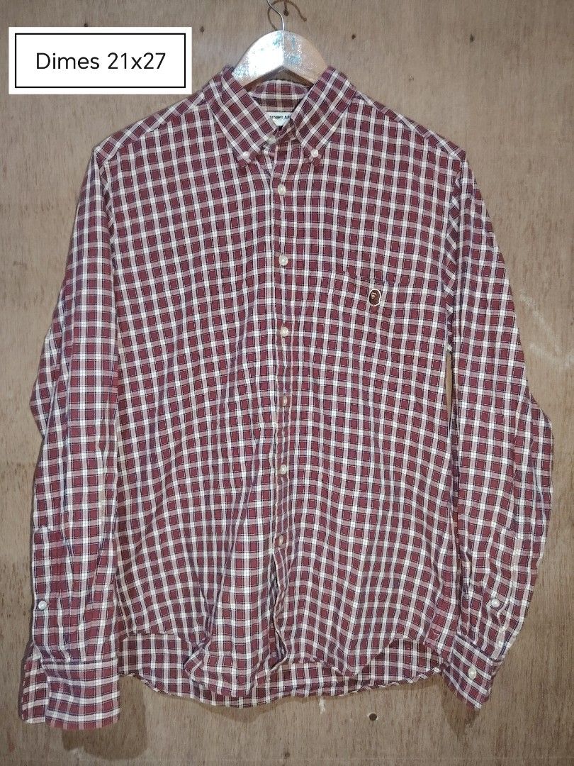 A Bathing Ape BAPE Plaid Button Down Shirt Maroon (Category: Tshirts & Polo Shirts ) located in Roxas, Palawan. Submitted by act_thrift_palawan (Listing ID 1470271779, Image 1). Description: - Brand: A Bathing Ape (BAPE) - Design: Red and white plaid button-down with long sleeves - Detail: Single chest pocket with embroidered ape head logo - Material: 100% Cotton - Origin: Made in Japan - Measurements: 21" (pit-to-pit) by 27" (length).