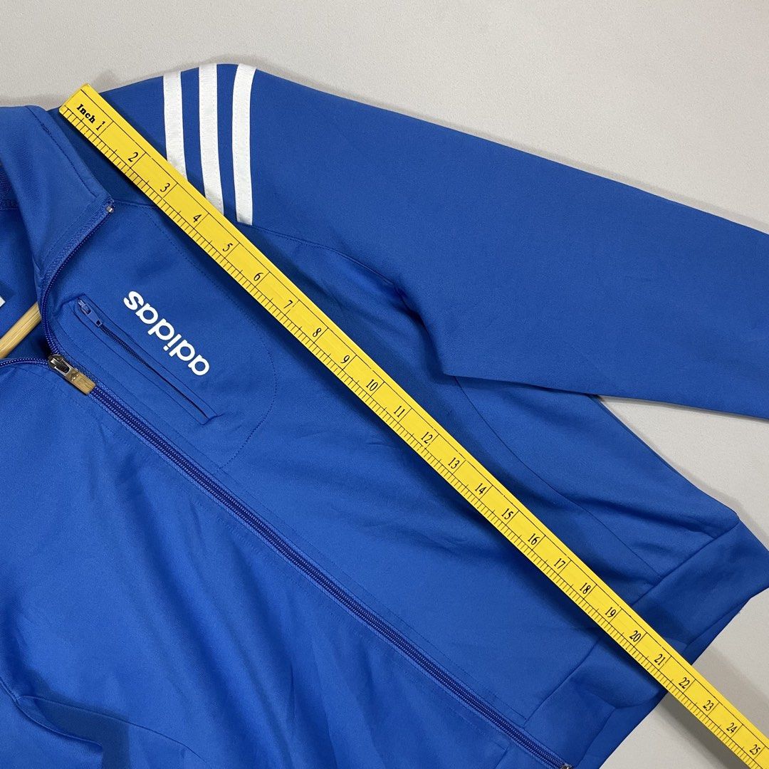 A D I D A S | Royal Blue Adidas Full-Zip Track Jacket (Category: Coats, Jackets and Outerwear) located in Norzagaray. Submitted by sevenjscloset (Listing ID 1470257552, Image 3). Description: Royal blue full-zip track jacket from Adidas. - White three-stripe branding on the shoulders and cuffs. - Vertical zippered chest pocket with Adidas lettering print. - Tagged size XXL, measures 21.5 inches in length and 18 inches in width. - Model in photos 