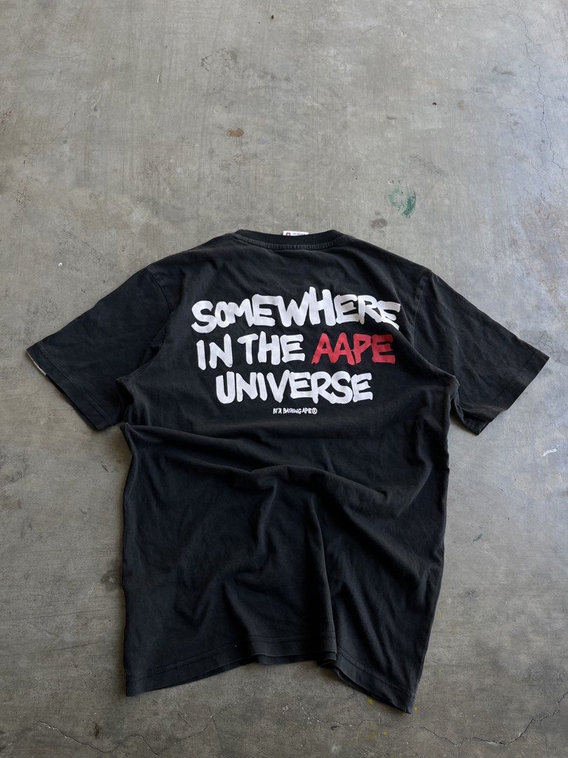 AAPE By A Bathing Ape Somewhere In The Universe Tee (Category: Tshirts & Polo Shirts ) located in Dipaculao. Submitted by _jzx.ph4lxfe (Listing ID 1470215428, Image 2). Description: - Brand: AAPE - Color: Washed black with worn-in finish - Size: Medium (M) - Design: Small rubberized logo patch on chest, large white and red back print - Details: Branded neck tape inside - Condition: Excellent pre-loved/ready to wear.