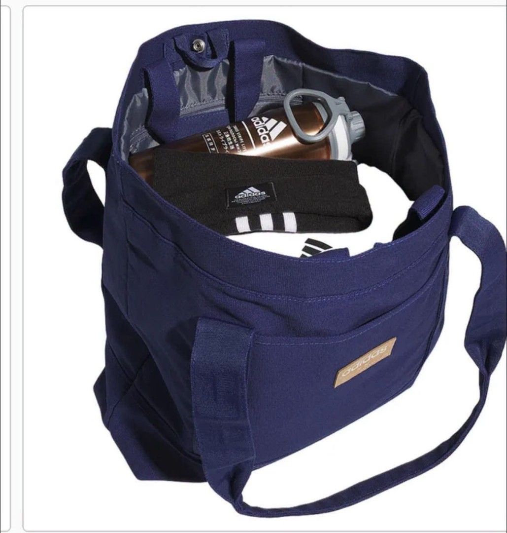 Adidas Blue Canvas Tote Bag (Category: Tote Bags) located in Dasmarinas. Submitted by cirila1212 (Listing ID 1470172390, Image 2). Description: - Brand: Adidas - Color: Navy blue - Material: Sturdy canvas with durable reinforced bottom - Design: Spacious main compartment and front pocket with a small brown leather patch logo - Features: Comfortable shoulder straps - Usage: Perfect everyday carryall; easily fits books, a laptop, and daily essentia