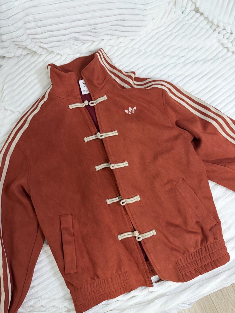 Adidas Chinese Knot Suede Track Jacket Rust Red (Category: Coats, Jackets and Outerwear) located in Rizal. Submitted by kianapreloves (Listing ID 1470237213, Image 1). Description: - Brand/Model: Adidas suede track jacket - Color: Rust red with deep red inner lining and white embroidered trefoil logo - Design: Stand-up collar with signature three stripes on sleeves - Closure: Unique combination of traditional Chinese knot buttons and front zipper