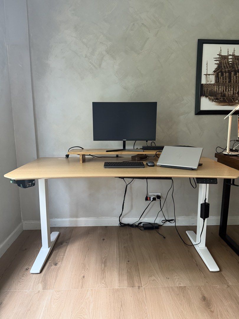 Adjustable Standing Desk/Office Desk with Wooden Top (Category: Office Furniture & Fixtures) located in Antipolo. Submitted by caialexis (Listing ID 1470278607, Image 1). Description: - Type: Motorized standing desk - Design: Light wood-finished top with sturdy white metal legs - Features: Digital height adjustment panel & built-in cable management tray - Condition: Excellent, clean modern setup - Best for: Home office or gaming station - Deliver