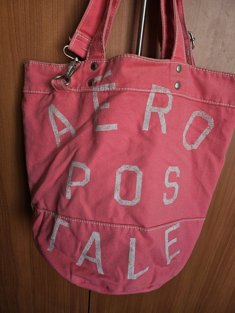 Aeropostale Pink Canvas Tote Bag (Category: Tote Bags) located in Mandaluyong City. Submitted by ohwmaria (Listing ID 1470237643, Image 2). Description: - Brand: Aeropostale - Color: Bright pink with white distressed lettering - Material: Durable heavy-duty cotton canvas - Features: Sturdy double handles, metal hardware, and interior pink zipper pocket with official brand tag - Usage: Ideal shoulder bag for school, work, or casual outings - Condi