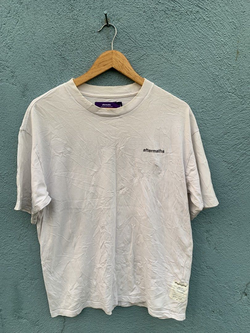 Aftermaths Graphic Tee White Size Small (Category: Tshirts & Polo Shirts ) located in Manila. Submitted by rommelx-07 (Listing ID 1470257228, Image 1). Description: - Brand: Aftermaths - Size: Small - Color: White with black back graphic - Details: Small chest logo, bold wave back print, purple heritage neck tag, woven hem patch - Fit: Relaxed everyday fit - Material: Comfortable cotton - Condition: Clean piece, highly versatile for denim or carg