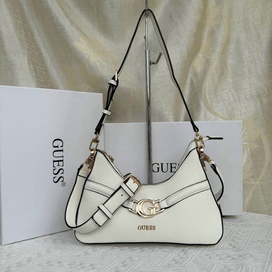 [ALL COLORS] GUESS Dea Shoulder Bag (Category: Shoulder Bags) located in Abucay. Submitted by erindeclutterss (Listing ID 1470349012, Image 2). Description: - Brand: GUESS - Available Colors: Black, White, Black Monogram, Brown Monogram - Features: Adjustable strap, gold-tone metal G logo buckle, and zip top closure - Design: Trendy structured slouchy shape - Packaging: Includes branded white box - Condition: Brand new and high quality - Size: 9 