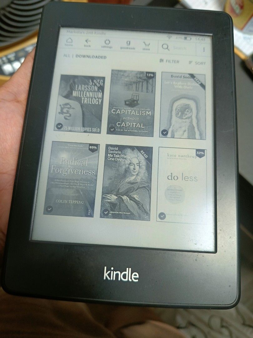 Amazon Kindle E-Reader (Category: E-Readers) located in Singapore. Submitted by livedog_7bdbb1 (Listing ID 1470301970, Image 2). Description: - Model: Amazon e-reader (Black) - Condition: Fully functional screen and battery; visible scratches on the back casing from normal use - Features: Clear display for reading, lightweight design, holds a great charge - Ports: Standard micro-USB charging port next to the power button - Perks: Perfect portable