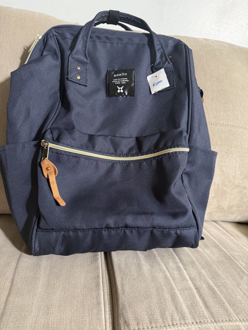 Anello Backpack (Category: Backpacks) located in Makati City. Submitted by triftedandbranded (Listing ID 1470230371, Image 1). Description: - Brand: Anello - Color: Dark blue canvas - Condition: Brand new with thrift store tag attached - Features: Structured-frame main zipper opening, double top handles with snap closure - Pockets: Front zipped pocket with leather-like pull tab and dual side slip pockets - Comfort: Adjustable back shoulder straps