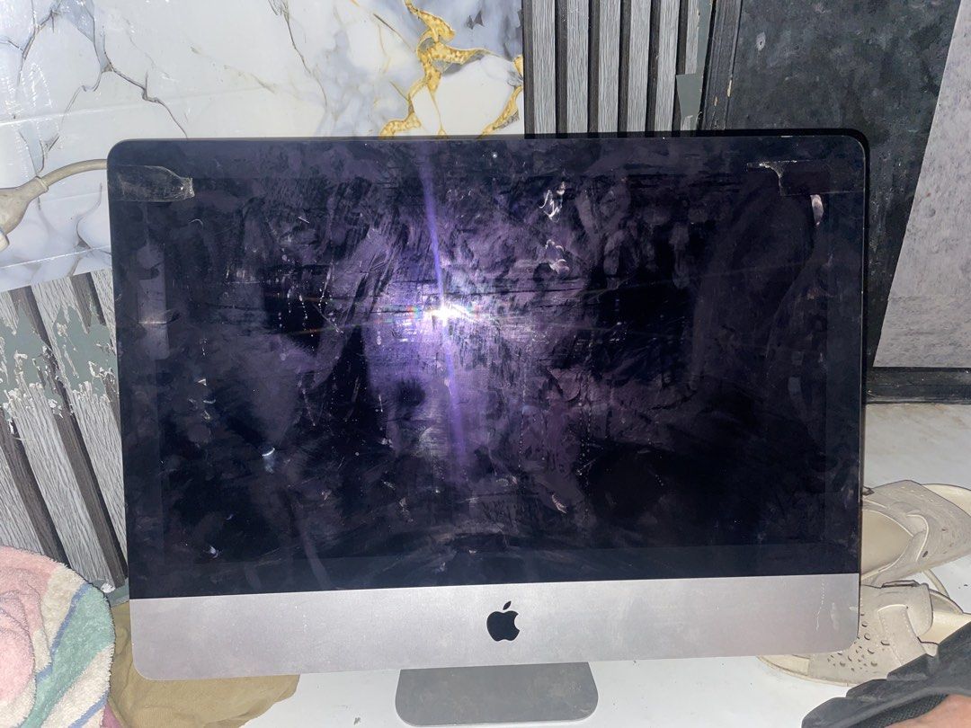 Apple iMac A1418 Desktop Computer (Category: Desktops) located in Caloocan City. Submitted by kennanmanalo (Listing ID 1470205731, Image 1). Description: - Model: Apple iMac A1418 - Color/Material: Silver aluminum body - Ports: Multiple USB ports, headphone jack, SD card slot, and Ethernet port - Condition: Powers on successfully; shows heavy dust, smudges, and dirt on the screen, back panel, and stand base (needs cleaning) - Features: Inventory 