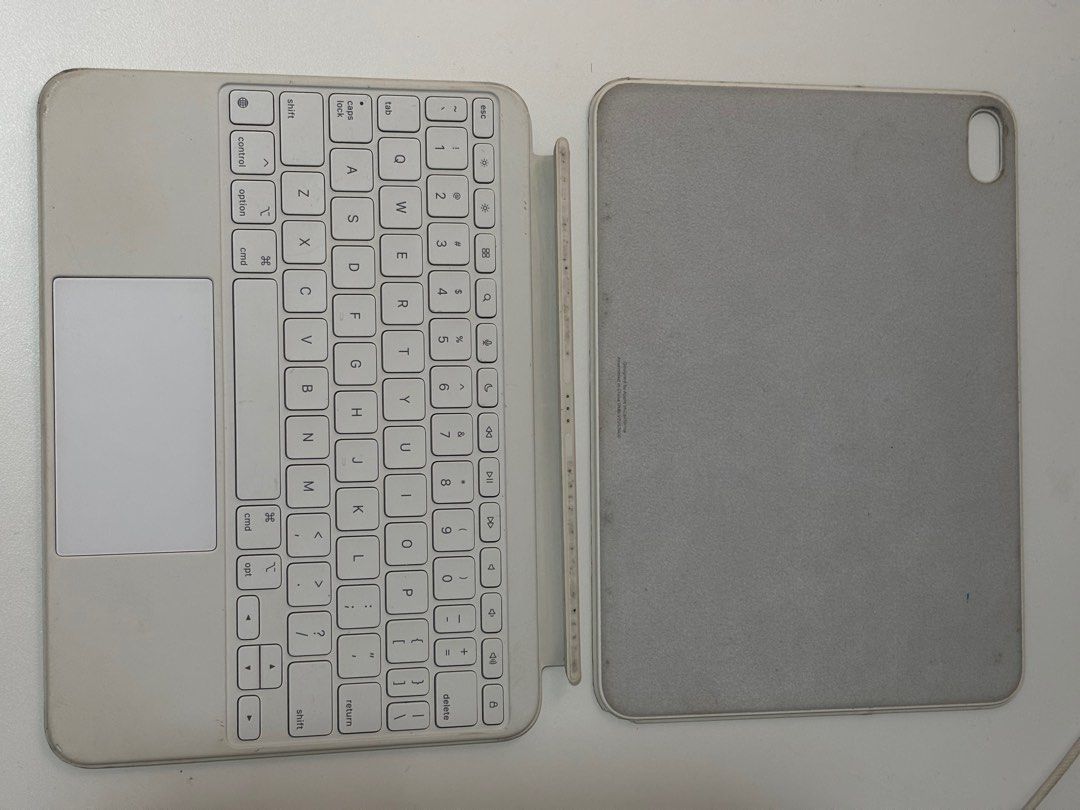 Apple Magic Keyboard Folio for iPad 10th Gen (Category: Cases & Sleeves) located in Taguig. Submitted by chewiechuchu (Listing ID 1470223663, Image 2). Description: - Authentic and original Apple Keyboard Folio for iPad 10th generation in white - Magnetic and detachable design - Keys and trackpad are 100% functional and intact - Note: Shows visible discoloration, dirt, stains, and sticker marks on the outer surfaces from daily use (priced accordi
