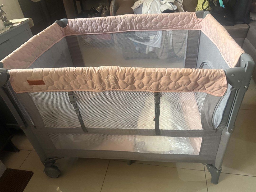 Apruva Baby Crib/Playpen (Category: Cots & Cribs) located in Agdangan. Submitted by ggboutique04 (Listing ID 1470336122, Image 3). Description: Selling a pre-loved Apruva Baby Crib / Playpen in a stylish grey and dusty pink design. Great condition overall, sturdy, and very convenient for daily use. Color: Grey & Dusty Pink Inclusions: Crib, Changing Table/Pad attachment, and Carrying Bag. Condition: Good pre-loved condition. Note: There is a stai