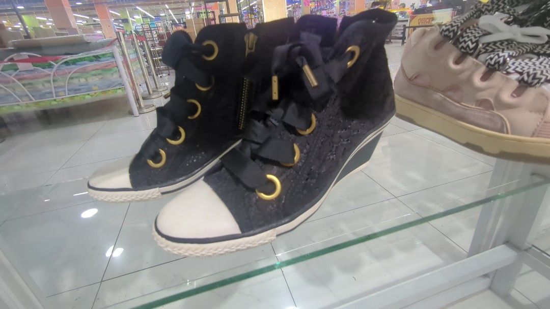 Ash Wedges Lacey Black Sneakers (Category: Sneakers) located in Cavite. Submitted by chocomint.bb (Listing ID 1470309515, Image 1). Description: - Size: 37 (marked clearly on inner sole) - Style: High-top wedge sneakers with extra height - Color/Material: Black patterned fabric upper with rubber toe caps - Details: Chunky ribbon laces and standard lace detailing - Hardware: Chic gold-tone eyelets and convenient side zippers.