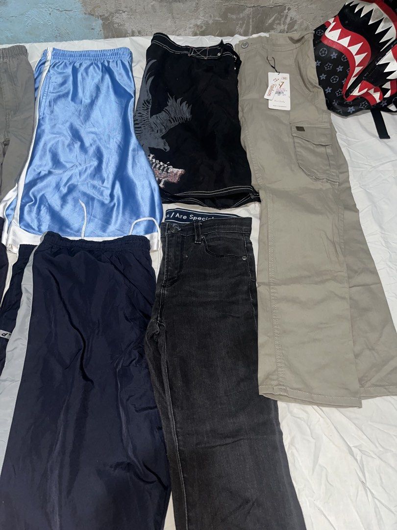 Assorted Pants and Shorts Bundle Multiple Styles Sizes (Category: Shorts) located in Manila. Submitted by unknownthrift. (Listing ID 1470346265, Image 2). Description: - All-in-one bundle of pants and shorts - Includes black jeans, blue basketball shorts, nylon track pants, and cargo pants - Colors: black, blue, navy, and grey - Versatile styles for casual or athletic wear - Great way to refresh your wardrobe rotation - Selling as a whole lot tog