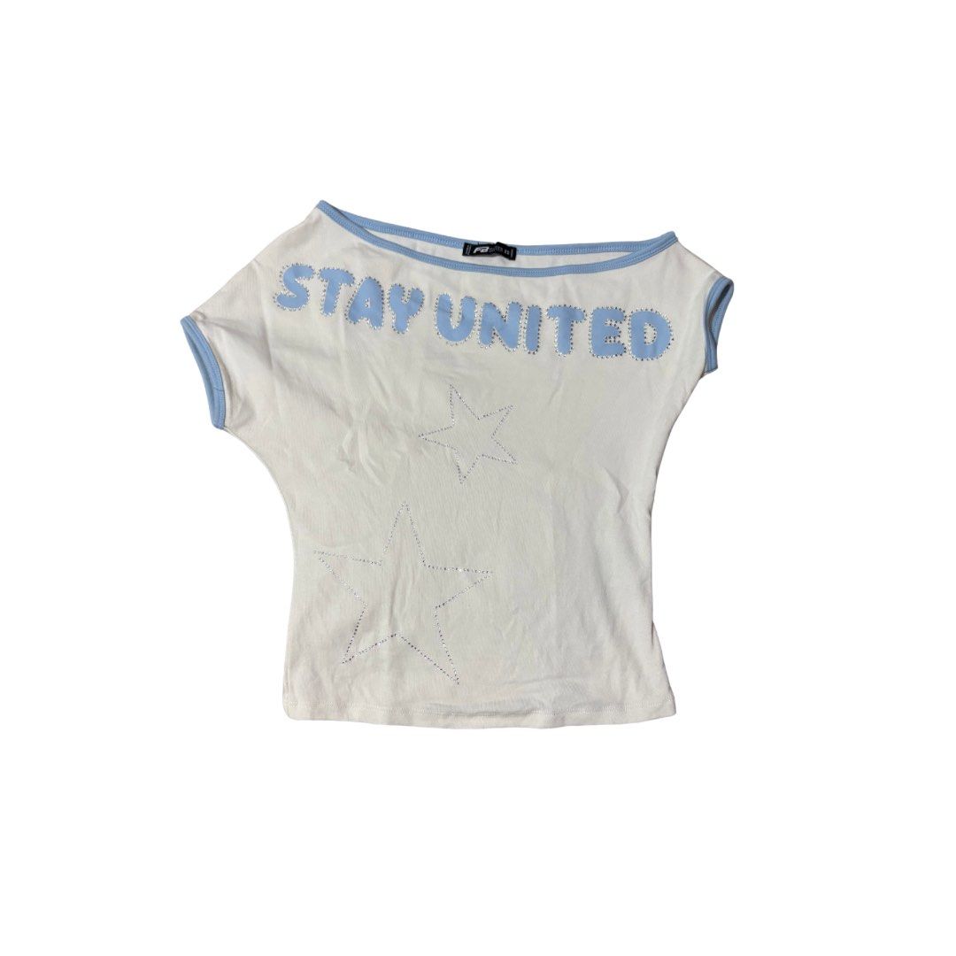 asymmetrical baby tee top (Category: Shirts) located in Cainta. Submitted by e11ise (Listing ID 1470235514, Image 1). Description: color: off white with baby blue trim deets: 'stay united' text with rhinestone outlines on the front condition: bnew (used twice).