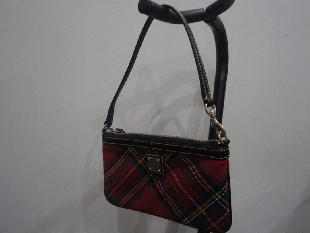 Authentic Dooney & Bourke Tartan Plaid Wristlet (Category: Luxury Bags & Wallets) located in Manila. Submitted by extras_bym (Listing ID 1470322059, Image 3). Description: - Brand: Dooney & Bourke - Design: Red tartan plaid with black leather trim and yellow contrast stitching - Hardware: Gold-tone with front metal logo plaque - Closure: Secure top zipper - Strap: Detachable black leather wrist strap - Size: Compact, ideal for cards, keys, and ph
