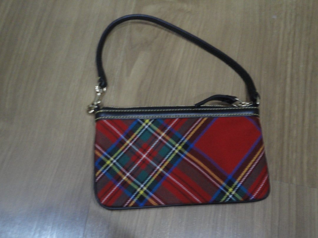 Authentic Dooney & Bourke Tartan Plaid Wristlet (Category: Luxury Bags & Wallets) located in Manila. Submitted by extras_bym (Listing ID 1470322059, Image 2). Description: - Brand: Dooney & Bourke - Design: Red tartan plaid with black leather trim and yellow contrast stitching - Hardware: Gold-tone with front metal logo plaque - Closure: Secure top zipper - Strap: Detachable black leather wrist strap - Size: Compact, ideal for cards, keys, and ph