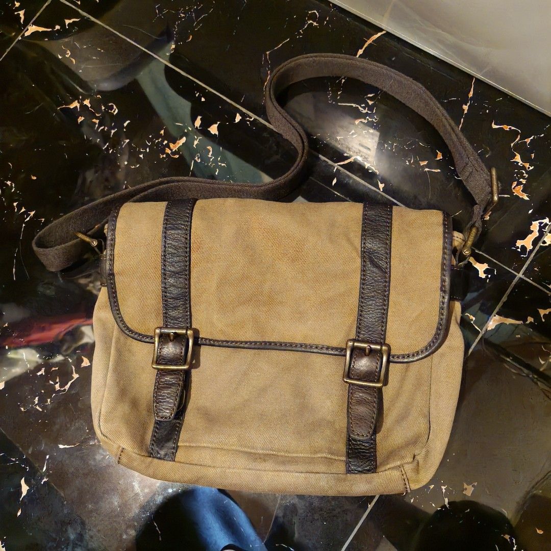Authentic Fossil Shoulder Bag (Category: Briefcases) located in Davao. Submitted by makmoonthriftdvo (Listing ID 1470277352, Image 1). Description: Authentic Fossil Shoulder Bag Model: MBG9117 28.5cm tall (11 inch) 36.5cm long (14 inch) Can fit Phone/Ipads Canvass material Brass buckles Leather Straps Double Push lock buckles back and front pockets Pen holder and Zipper pocket with 3 extra compartments inside No issue DM 📩📩 DAVAO.