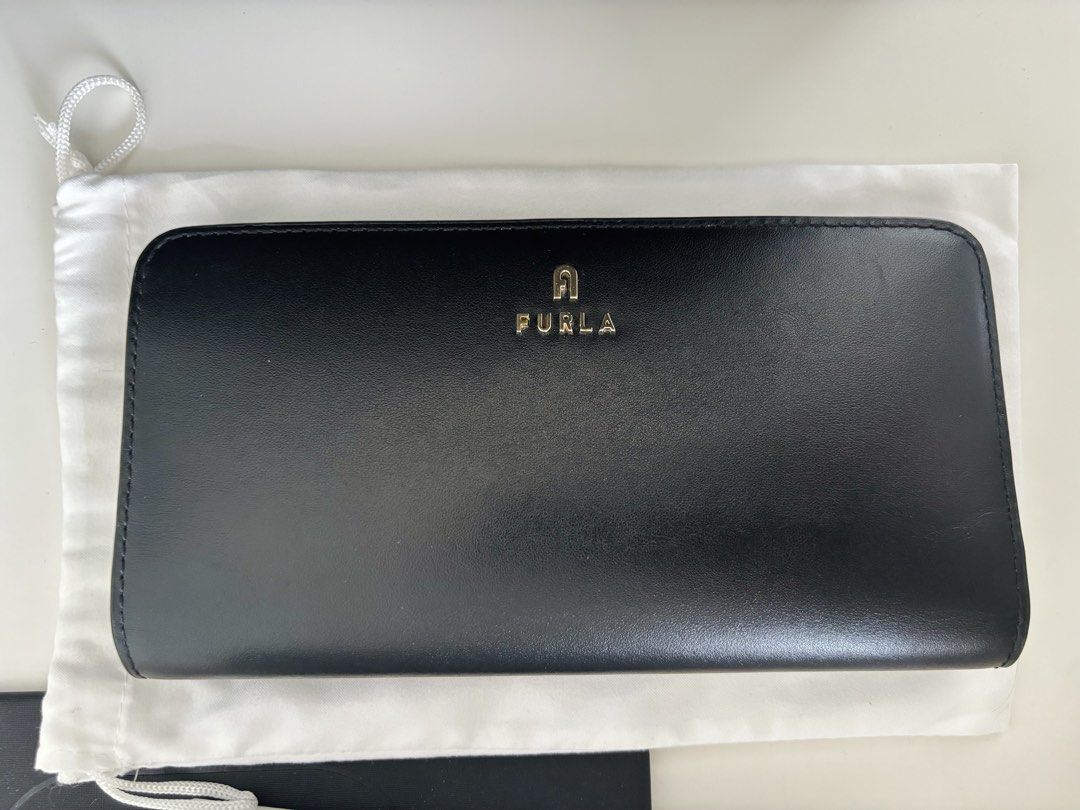 AUTHENTIC Furla Camelia XL Zip Around Slim Wallet (Category: Wallets & Card holders) located in Manila. Submitted by lxi16 (Listing ID 1470210744, Image 1). Description: - Brand: Furla - Material: Genuine black leather - Design: Slim zip-around with multiple card slots and compartments - Hardware: Elegant gold tone with front logo lettering - Condition: like new, used twice - Inclusions: Original box, tags, care booklet, and dust bag.