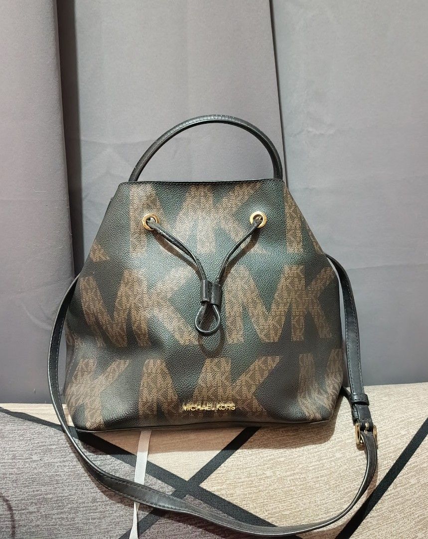 AUTHENTIC Michael Kors Bucket Bag (Category: Luxury Bags & Wallets) located in Quezon City. Submitted by kazuxxxx (Listing ID 1470170055, Image 1). Description: - Brand: Michael Kors - Color: Dark Brown with signature MK monogram and black leather trim - Hardware: Gold-tone - Closure: Drawstring top - Straps: Short top handle and adjustable long strap for crossbody wear - Details: Small gold Michael Kors lettering on the front.