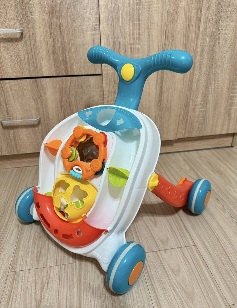 Baby Push Walker and Play Center (Category: Infant Playtime) located in Manila. Submitted by carad__ (Listing ID 1470185564, Image 1). Description: - Multi-colored toddler activity walker with easy-grip blue handlebars and bright orange wheels - Interactive front panel includes various toys, spinning gears, shape sorters, and a safe mirror - Sturdy four-wheel base offers great support for babies learning to walk - Clean, 100% functional, and read