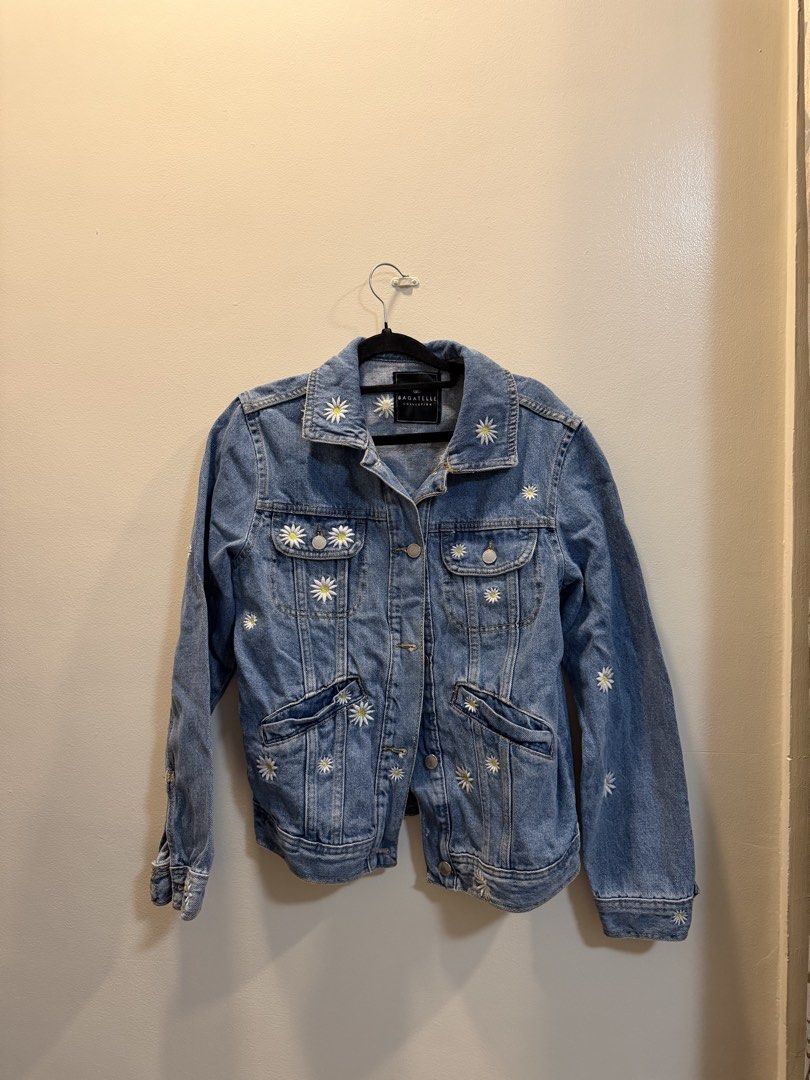 Bagatelle Collection Daisy Embroidered Denim Jacket | S (Category: Coats, Jackets and Outerwear) located in Caloocan City. Submitted by hobieshome (Listing ID 1470291459, Image 1). Description: - Brand: Bagatelle Collection - Design: Medium wash denim with embroidered white daisies on body and collar - Closure: Front button-up with metallic buttons - Pockets: Dual chest flap pockets and lower welt pockets - Details: Pointed collar, long sleeves w
