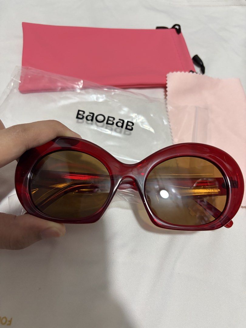 Baobab Elba in Cherry Red Sunglasses (Category: Sunglasses & Eyewear) located in Valenzuela. Submitted by cheaper_finds (Listing ID 1470152892, Image 3). Description: - Brand: Baobab - Model: Elba - Color: Cherry red thick acetate frames with brown tinted lenses - Condition: Brand new, never worn, still sealed in original packaging - Inclusions: Complete set with branded ziplock pouch, pink protective soft sleeve, and matching microfiber cleaning
