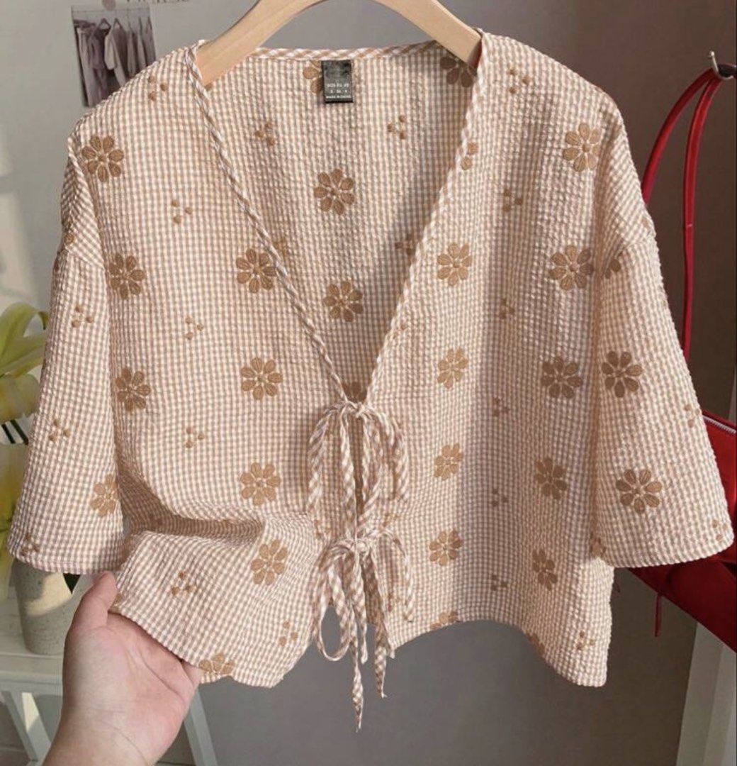 Beige Gingham Floral Tie-Front Crop Blouse (Category: Blouses) located in Manila. Submitted by nillomarid70318 (Listing ID 1470298322, Image 1). Description: - Style: Cute casual crop top - Pattern: Beige and white check with brown embroidered daisies - Details: Deep V-neckline, double front tie closures - Material: Textured seersucker fabric - Fit: Relaxed, boxy fit with half sleeves - Length: Short cropped.