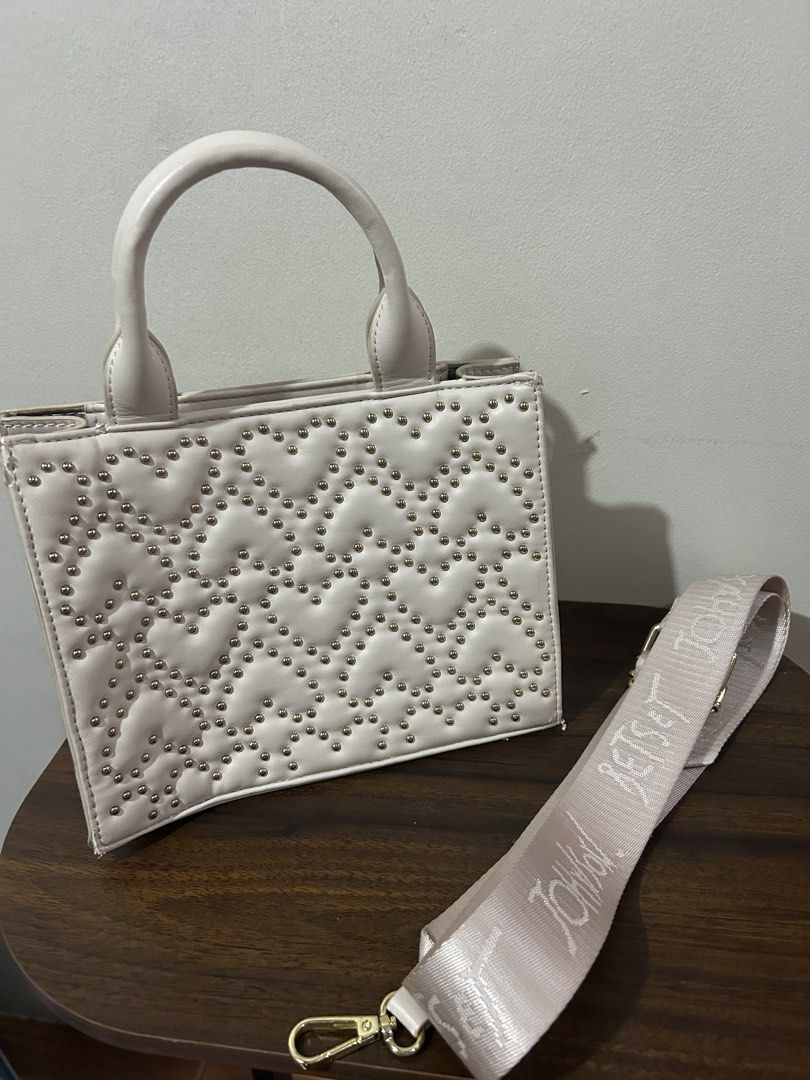 Betsey Johnson Off-White Structured Handbag with Branded Strap (Category: Luxury Bags & Wallets) located in Marilao. Submitted by bamito (Listing ID 1470166884, Image 2). Description: - Color: Off-white with gold-tone hardware - Style: Structured handbag / top-handle bag - Closure: Secure top zip - Straps: Double top handles + wide removable canvas shoulder strap with repeating text pattern.