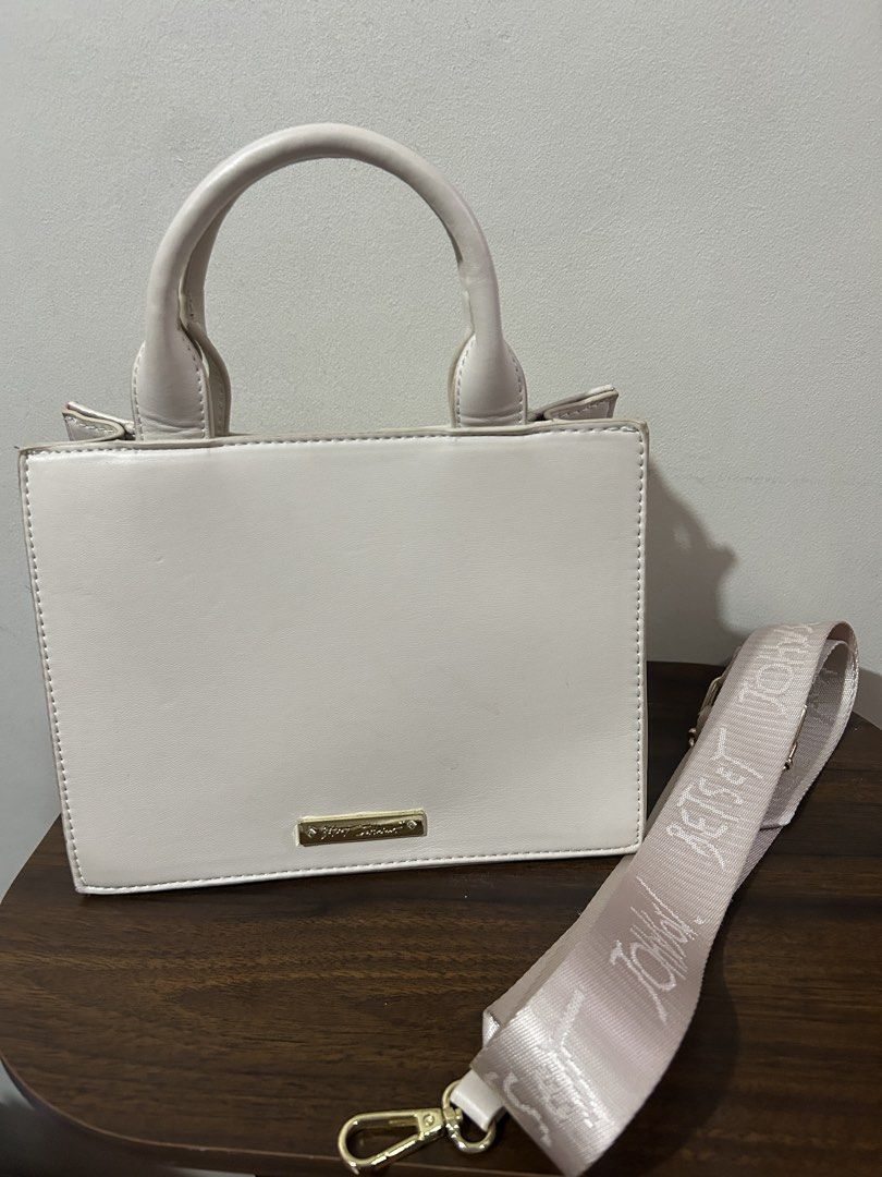 Betsey Johnson Off-White Structured Handbag with Branded Strap (Category: Luxury Bags & Wallets) located in Marilao. Submitted by bamito (Listing ID 1470166884, Image 1). Description: - Color: Off-white with gold-tone hardware - Style: Structured handbag / top-handle bag - Closure: Secure top zip - Straps: Double top handles + wide removable canvas shoulder strap with repeating text pattern.
