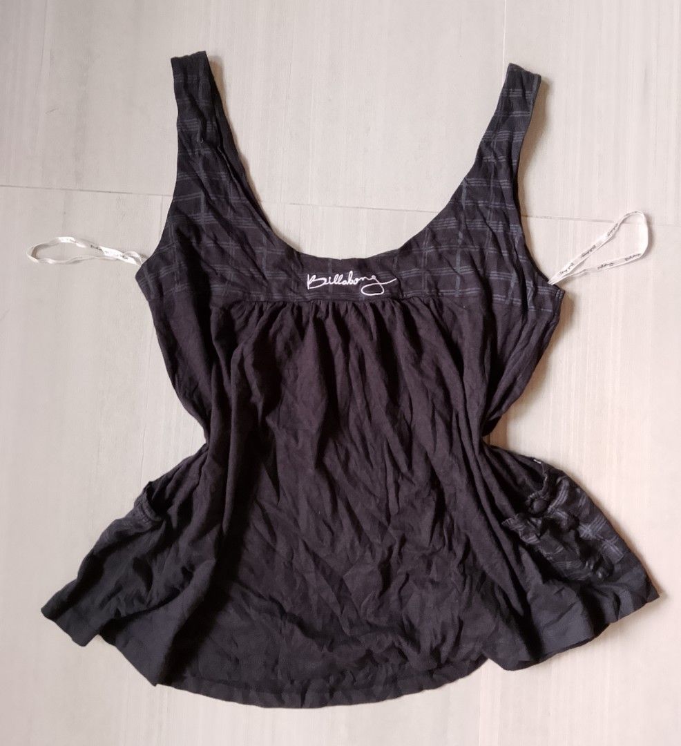 Billabong Black Tank Top Size 12 (Category: Sleeveless) located in Manila. Submitted by keencrystal.595c28 (Listing ID 1470252943, Image 3). Description: - Brand: Billabong - Size: 12 - Material: 100% lightweight cotton (great for warm weather) - Color: Classic black - Design: Subtle check pattern, scooped neckline, and gathered bodice with button detail - Branding: Embroidered logo near the hem - Condition: Excellent / Ready to wear.